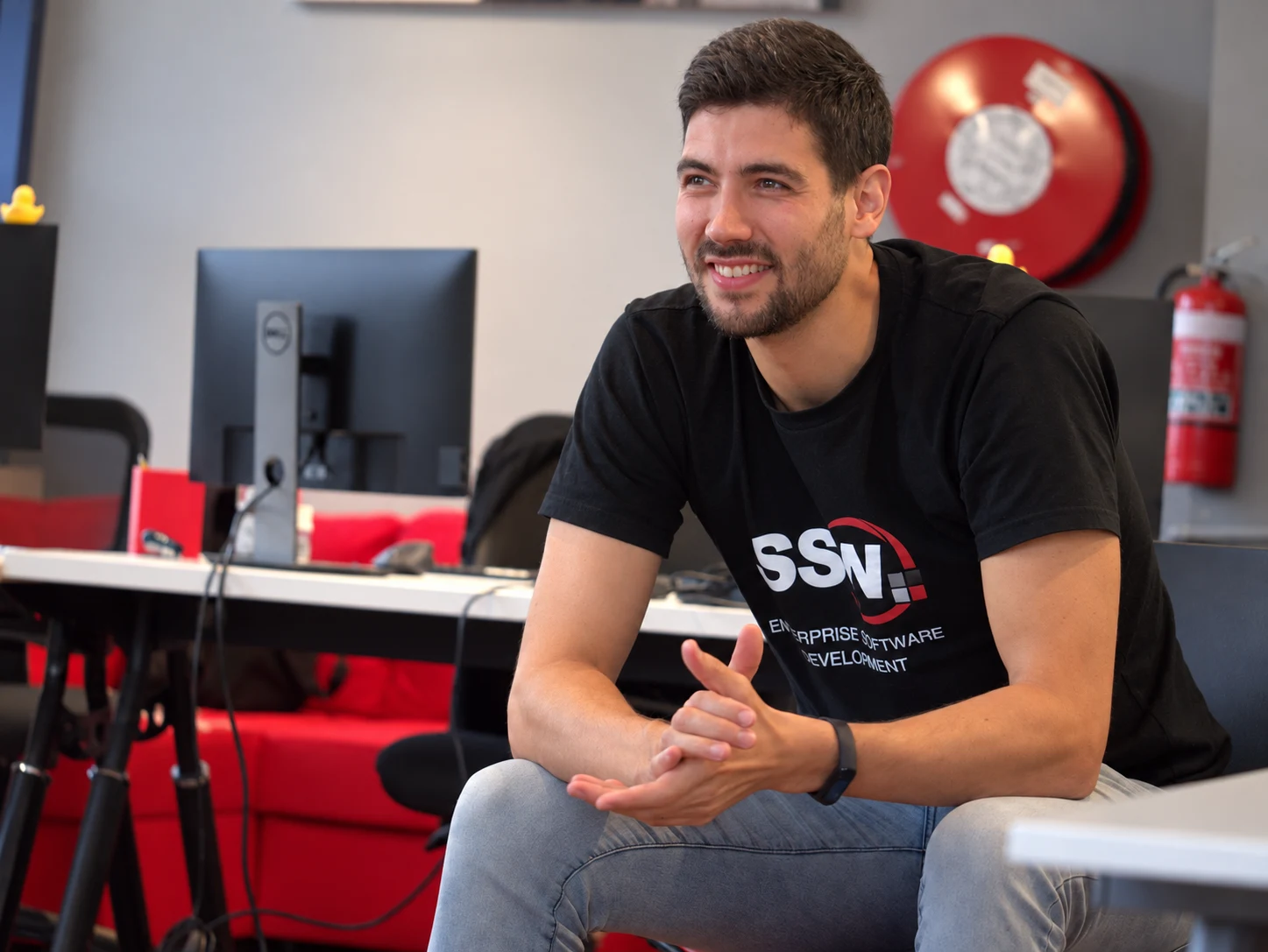 Ulysses Maclaren seated in an office, wearing an SSW T-shirt